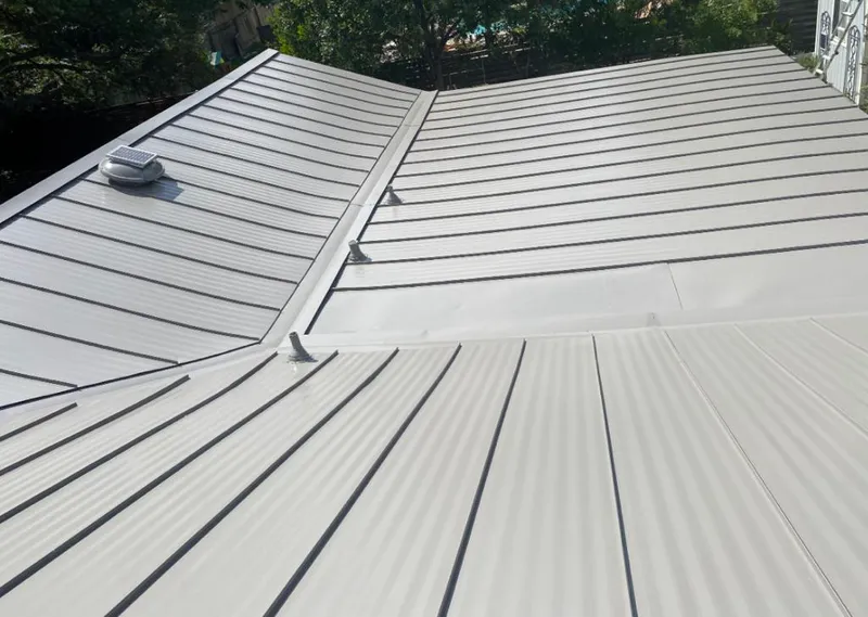 Solar attic fan installed on a metal roof for Roof Ventilation in Stowe